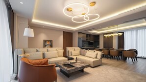 Ein modernes Wohnzimmer mit einem Ecksofa, einem Couchtisch und einem Essbereich mit Stühlen und einem Tisch.