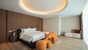 Ein modernes Schlafzimmer mit einem Bett, Nachttischen, einem Sofa und einem einzigartigen Teppich in Form eines Bären.