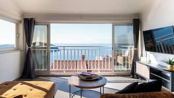 Departamento, vista al mar | Área de sala de estar | Smart TV de 80 cm con canales por cable