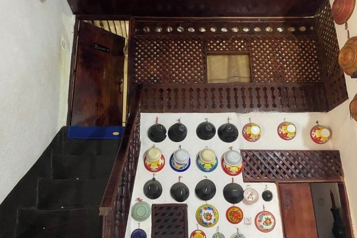 A staircase with a wall-mounted display of various ceramic plates and bowls.