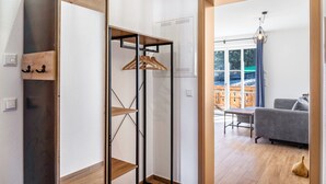Une chambre moderne dotée d’une armoire en bois, d’un porte-manteau et donnant sur un balcon extérieur.