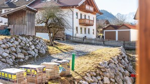 Un bâtiment rural doté d’un balcon, d’un mur en pierre et de caisses en bois.