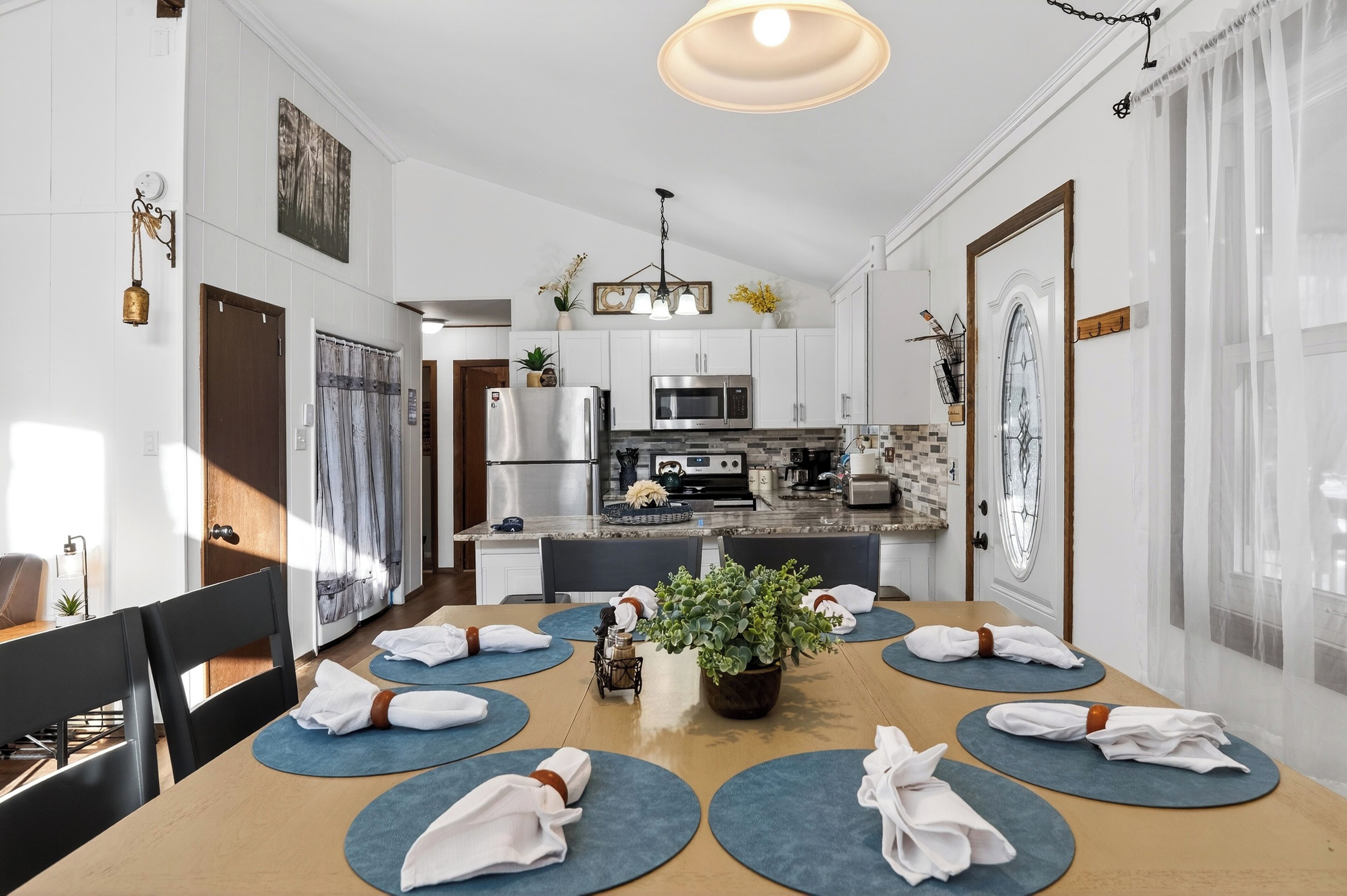 A modern kitchen with white cabinets, a stainless steel refrigerator, and a microwave.