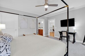 A bedroom with a large bed, a desk, a chair, a television, and a ceiling fan. - 5 Units w/ Free Parking • Walkable Historic District | The Juliette by AvantStay (Savannah)