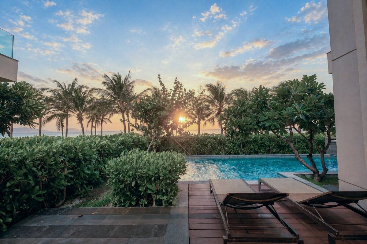 Ein Poolbereich mit Blick auf den Sonnenuntergang, Palmen und eine Holzterrasse.