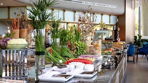Ein reichhaltiges Buffet mit verschiedenen Speisen und dekorativen Pflanzen.