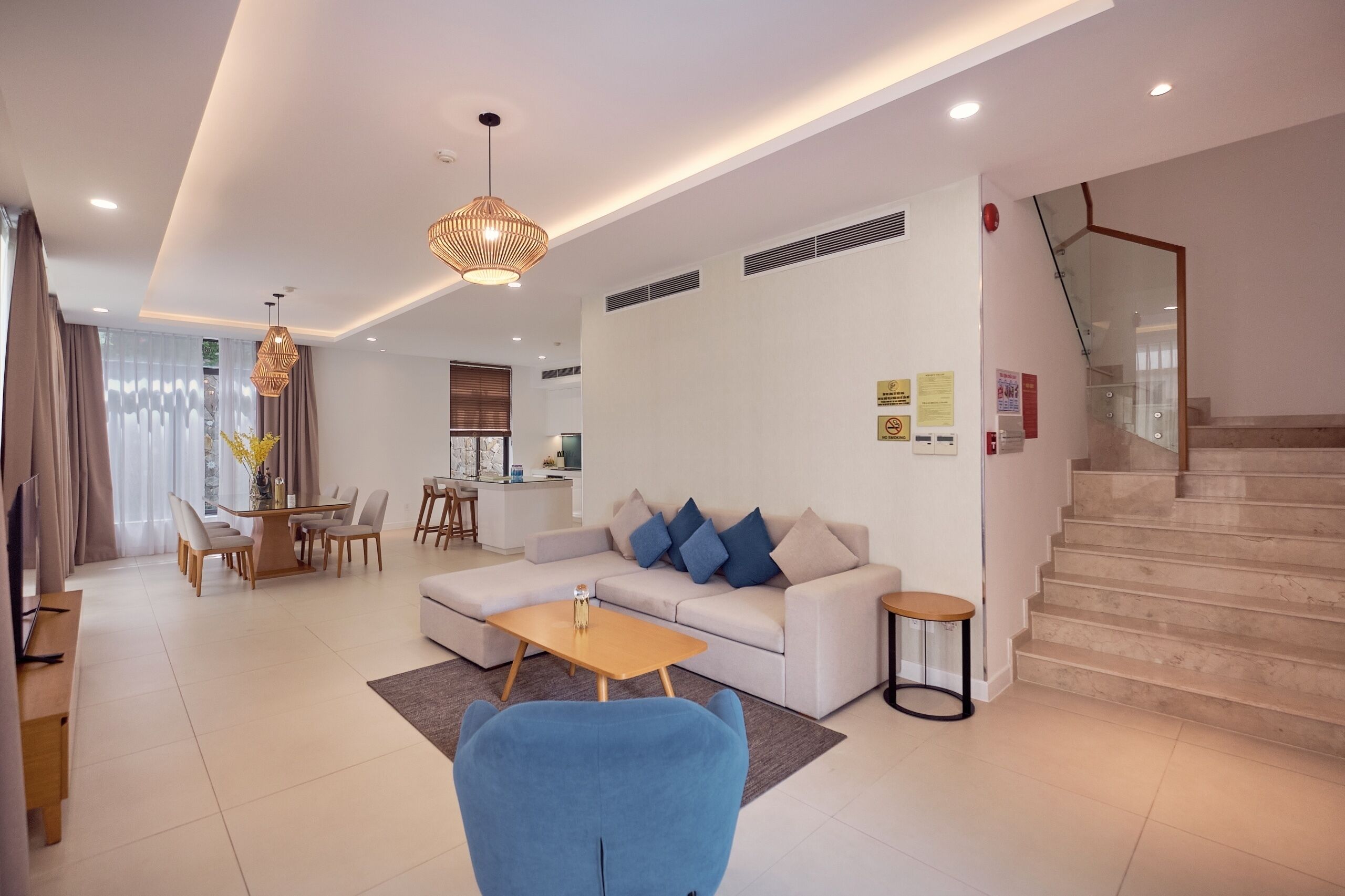 Un salon moderne avec un canapé, une table basse et un fauteuil bleu.