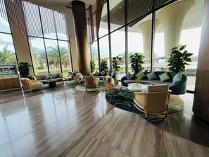 A spacious lobby with a modern design, featuring a mix of seating arrangements and large windows offering views of the outdoors. - Sunrise Pool Villa Cam Ranh  (Cam Lam)