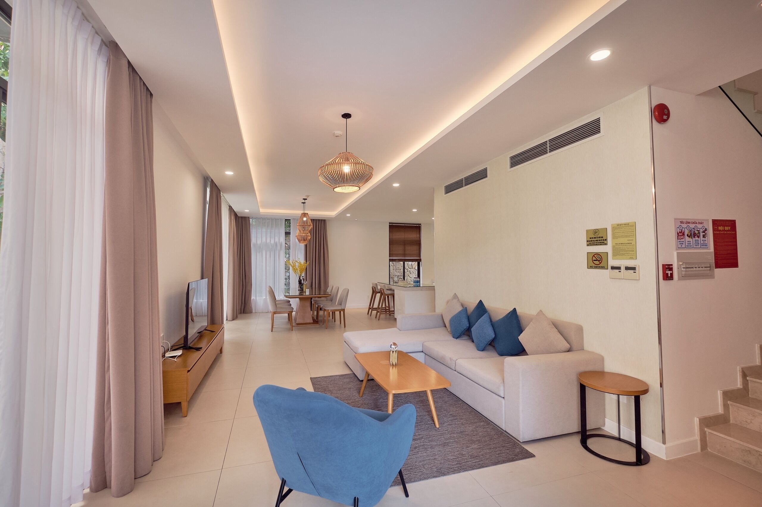 Een moderne woonkamer met een bank, salontafel, televisie en eethoek.