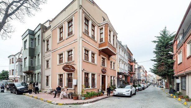 Ein Eckgebäude mit einem Schild, auf dem „Sultan House Hotel“ steht.