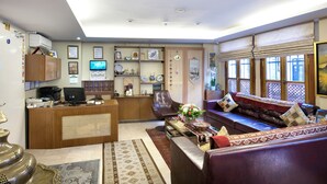 Eine Hotelhalle mit Rezeption, Sitzgelegenheiten und Dekorationselementen.