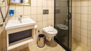 Ein Badezimmer mit Waschbecken, Spiegel, Toilette und Dusche.