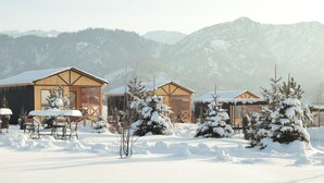A snow-covered lodge with wooden cabins and a mountain backdrop. - Delightful 1-bedroom villa with mountain view in Almaty (Besqaynar)