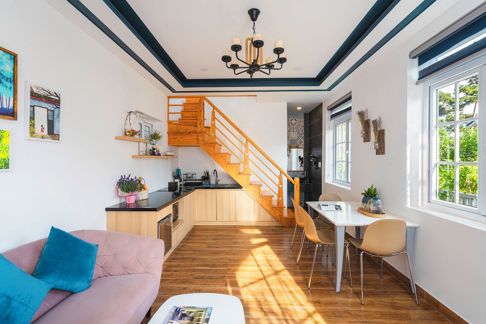 Un intérieur moderne avec un escalier en bois, un coin repas et un espace de vie comprenant un canapé et une table basse.