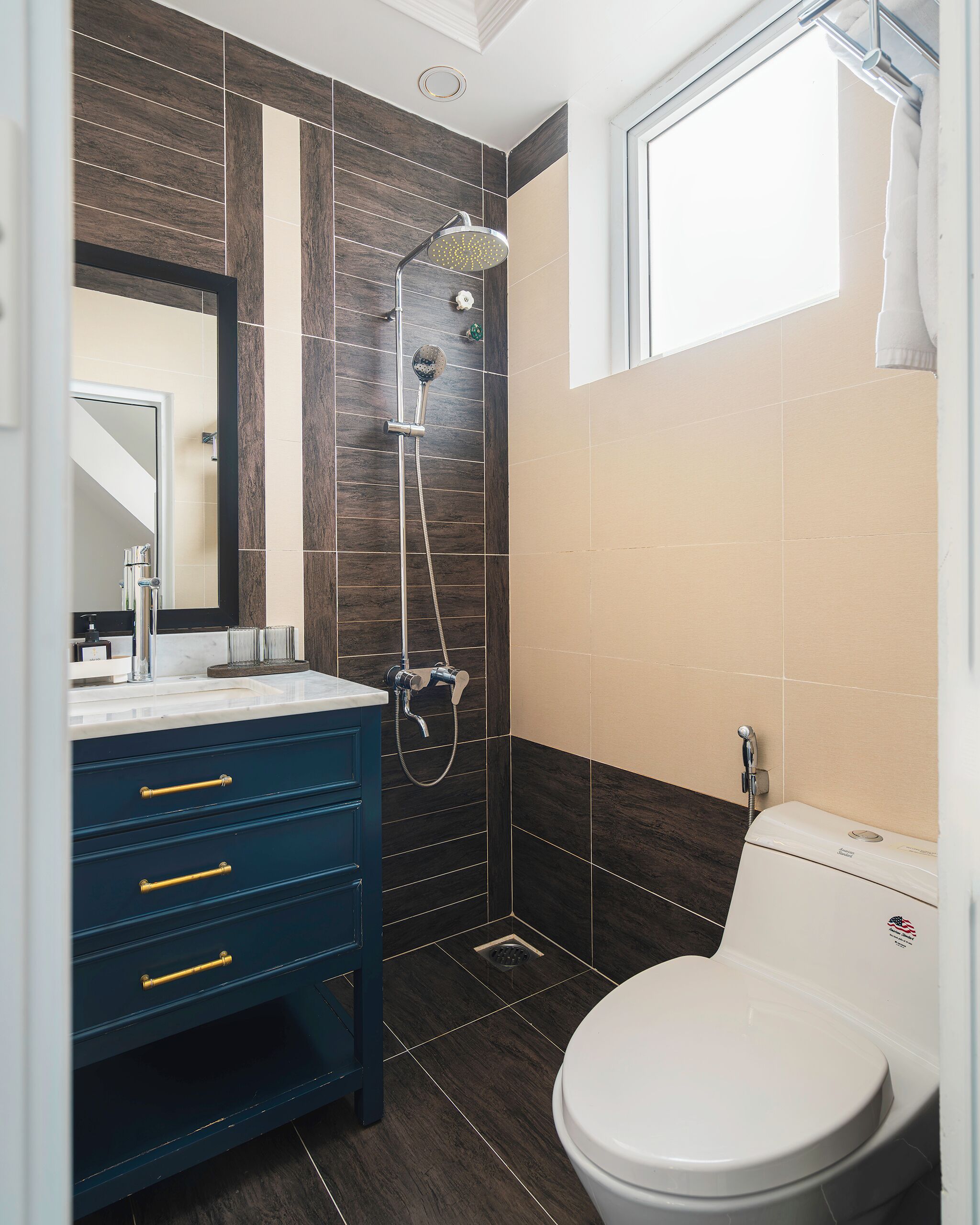 A bathroom with a shower, toilet, and vanity with drawers.