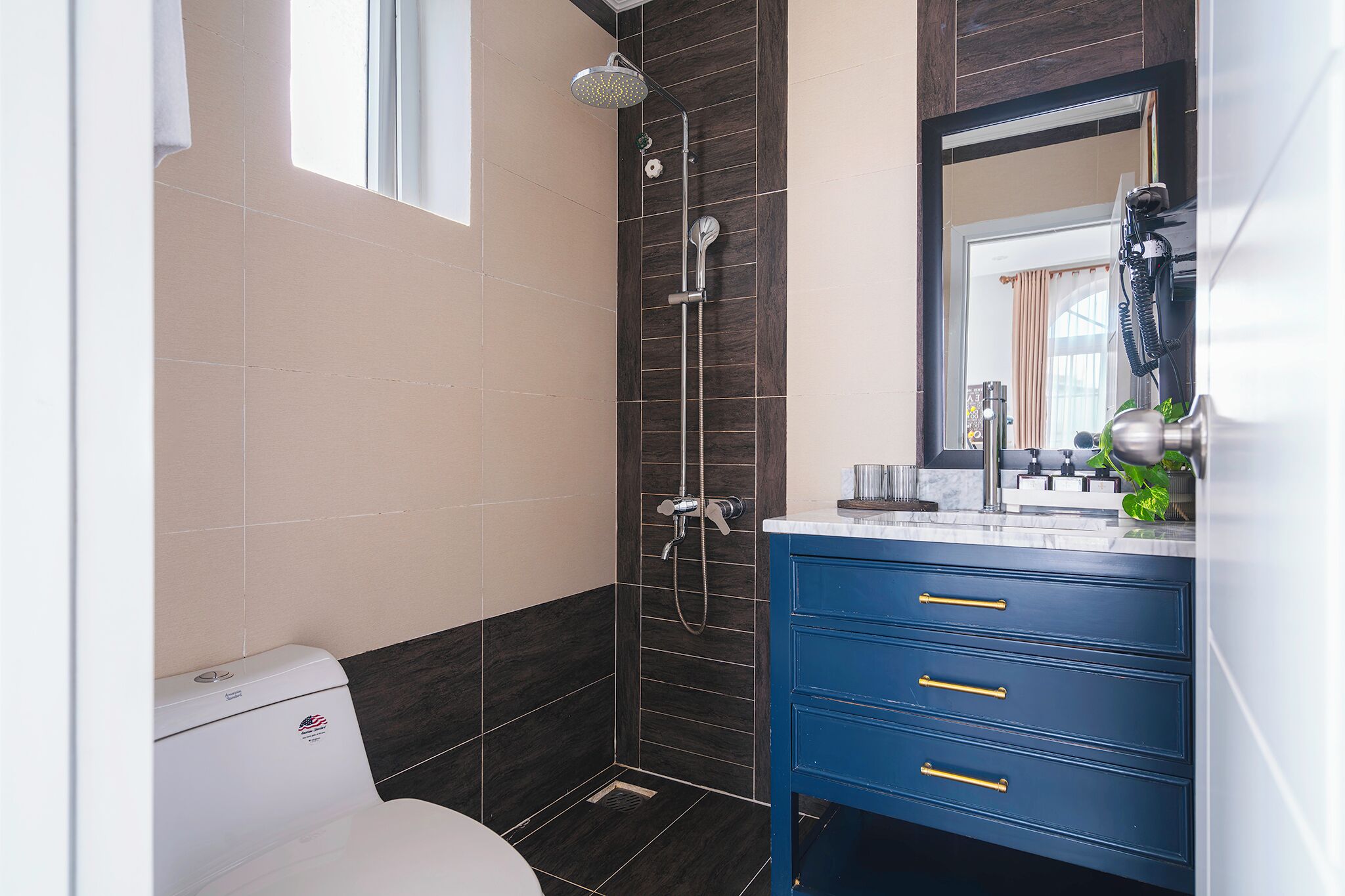 A bathroom with a shower, toilet, and vanity with drawers.