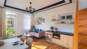 Un salon moderne comprenant un canapé, une table à manger et un coin cuisine.