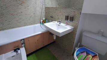 A bathroom with a bathtub, a sink, and a toilet.