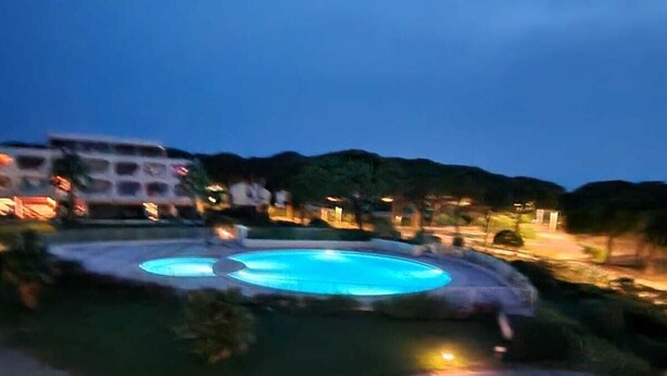 A swimming pool surrounded by a landscaped area with pathways and greenery. - Apartment in Port Camargue Plage Nord sea view Swimming pool (Le Grau-du-Roi)