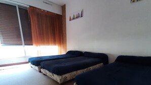 A room with two beds, a window with curtains, and a wall-mounted decoration. - Apartment in Port Camargue Plage Nord sea view Swimming pool (Le Grau-du-Roi)