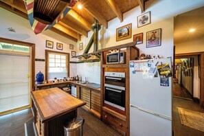 Une cuisine avec des meubles de rangement en bois, un four à micro-ondes encastré et un réfrigérateur.