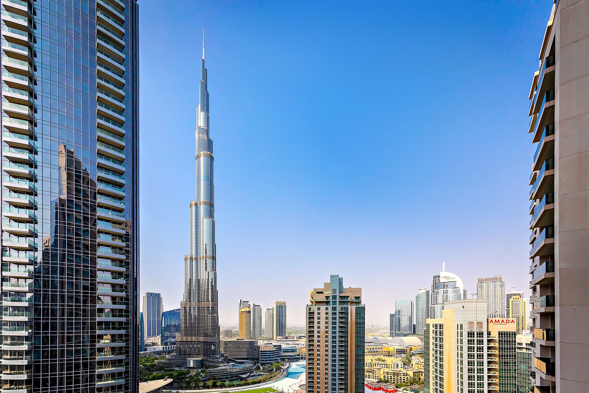 A high-rise building with a distinctive spire, surrounded by other modern skyscrapers.