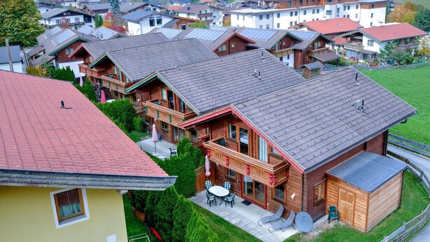 Un gruppo di case in legno con un patio e un piccolo deposito.