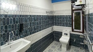 Un baño con techo de madera, inodoro, lavamanos y ducha.