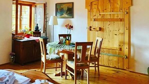 A rustic room with wooden furniture, a dining table, a wooden door, and a painting on the wall. - Pension Leopoldine (Hallstatt)