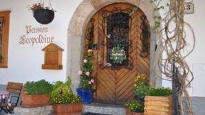 A wooden door with a wrought iron gate, potted plants, and a welcome sign. - Pension Leopoldine (Hallstatt)