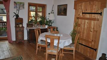 Una mesa de comedor de madera con sillas, un aparador de madera, una ventana y una puerta de madera.
