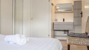 Een hotelkamer met een bed, een badkamer met een spiegel, een wastafel en een kast.