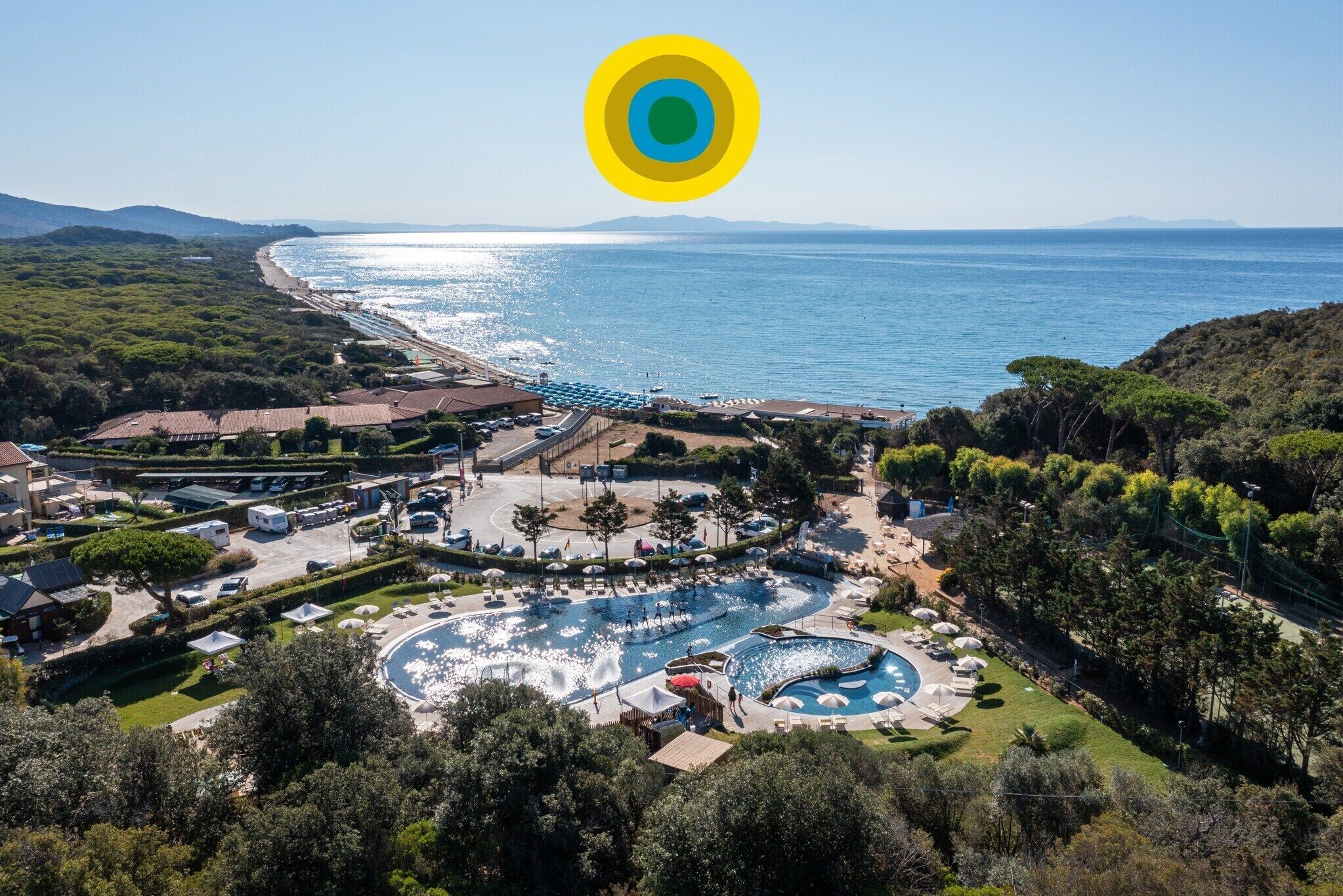 A resort with a large pool, a water slide, and a beach view.