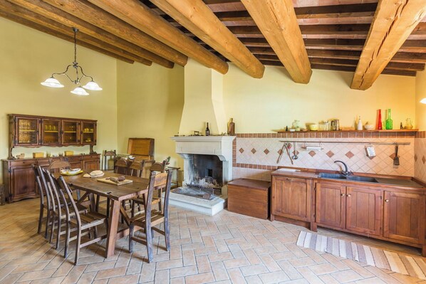 A rustic kitchen with exposed wooden beams, a fireplace, and a tiled backsplash. - Villa Felice, private pool and hills (Mezzanotte)