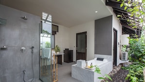 A modern bathroom with a glass-enclosed shower, a marble sink, and a small seating area with a plant. - Peacefully, 3 Bedroom Villa in Seminyak (Seminyak)