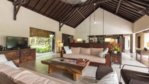 A spacious living area with a large wooden coffee table, sofas, and a television. - Peacefully, 3 Bedroom Villa in Seminyak (Seminyak)