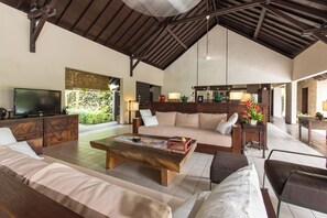 A spacious living area with a large wooden coffee table, sofas, and a television. - Peacefully, 3 Bedroom Villa in Seminyak (Seminyak)