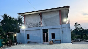 Un bâtiment à deux étages, doté d’un toit plat, d’une grande cour intérieure et d’une entrée fermée par un portail.