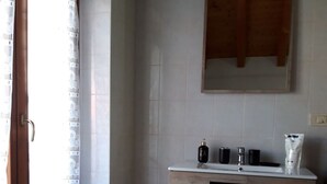 Ein Badezimmer mit Holzkabinent, einem Spiegel und einem Waschbecken.
