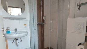 A modern bathroom with a glass-enclosed shower, a white sink, and a toilet. - FeWo Fokko - Away from the hustle and bustle (Norden)