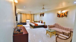 A hotel room with a bed, a sofa, a coffee table, and a desk with a lamp. - Konaark's Arka Hotels Nagpur  (Nagpur)