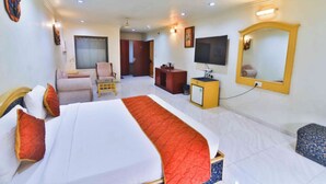 A hotel room with a bed, a television, a desk, a chair, a wardrobe, and a mirror. - Konaark's Arka Hotels Nagpur  (Nagpur)
