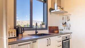 Una cucina moderna con finestra, elettrodomestici in acciaio inossidabile e vista sul deserto.
