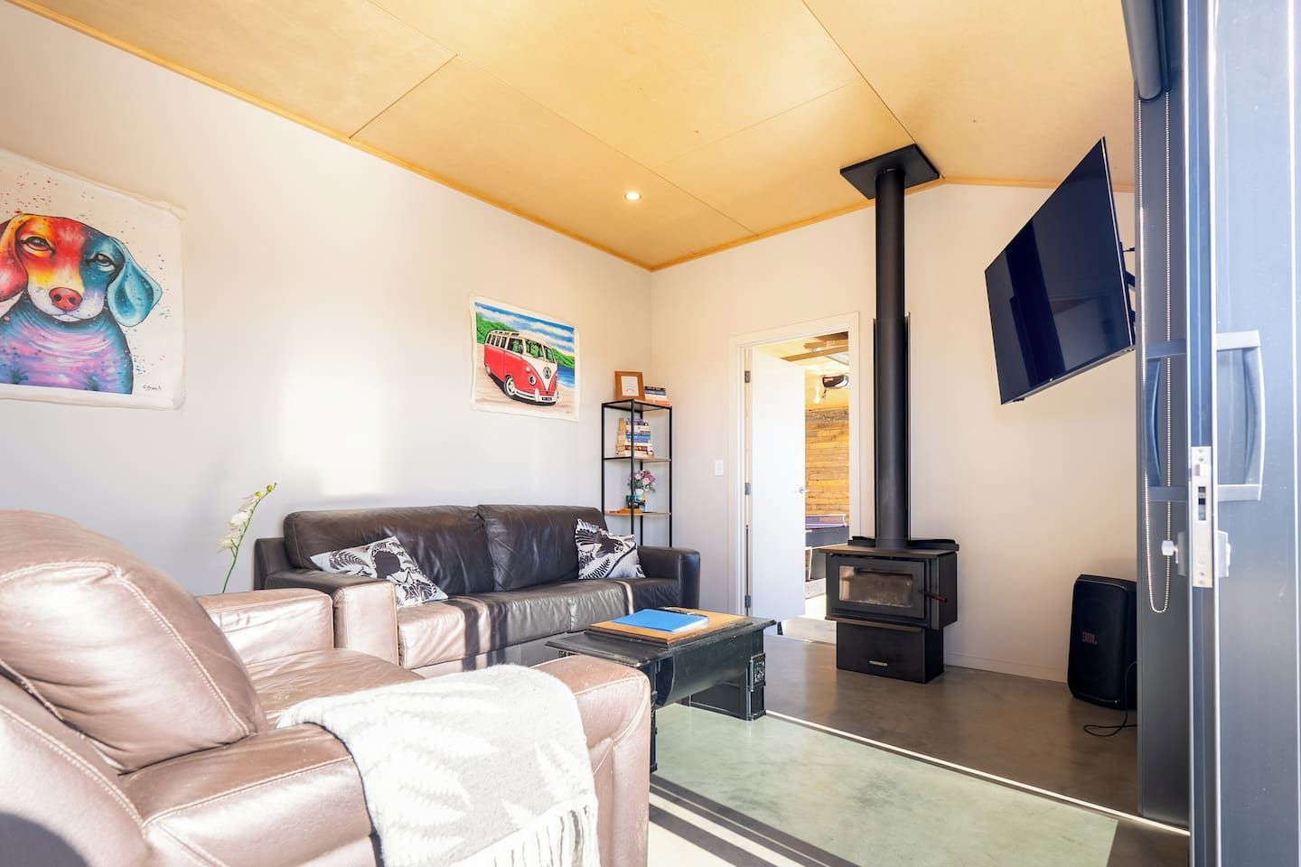 A living room with a sofa, a flat-screen TV, a fireplace, and a bookshelf.