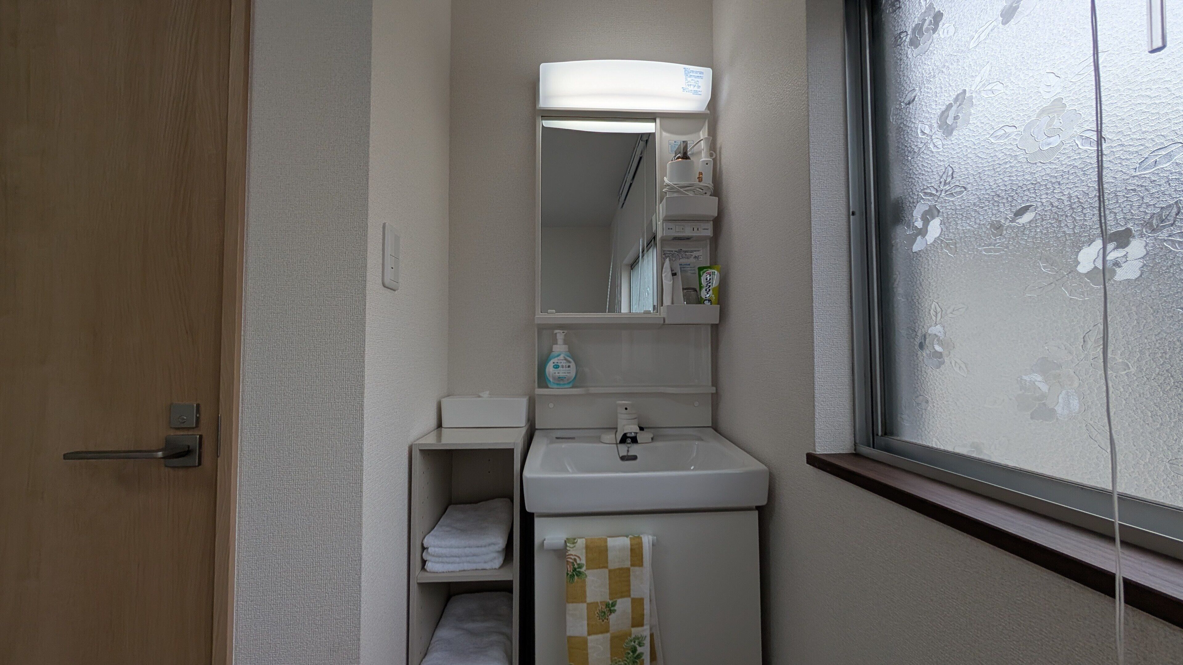 A bathroom with a sink, mirror, and towel rack.
