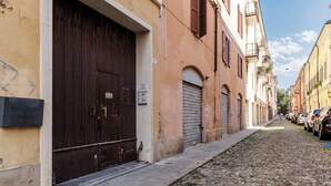 A narrow cobblestone street lined with historic buildings, featuring closed shutters and a mailbox. - House Chiara| WiFi Parking Station downtown Modena (Modena)