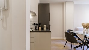 A modern kitchen with a built-in stove, a coffee maker, and a knife block. - Casa Valentina | WiFi Stazione Treni Parking (Modena)