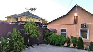 Un quartier résidentiel comprenant une maison, une cour clôturée et un petit jardin.
