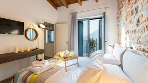 A hotel room with a bed, a bedside table with a tray of breakfast, a mirror, and a view of the outdoors. - Beautiful sea views, Close to Beautiful Beaches of South Crete (Rethymno)