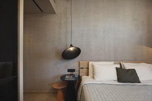 Ein Schlafzimmer mit einem Bett, einem Nachttisch mit Lampe und einer Wandleuchte.